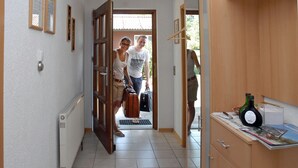 A hallway with a radiator, wooden cabinets, and a door leading to another room. - Ferienwohnung Singer (Schnaittach)