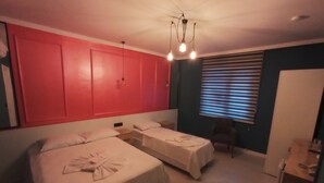 A room with two beds, a chair, a desk, and a window with blinds. - Oropa Butik Hotel (Eynesil)