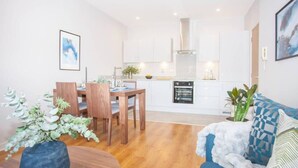 A modern apartment with a dining area, kitchen, and living room. - Stylish 2-Bed Apartment Near Glasgow Green (Glasgow City)