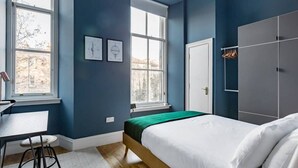 A bedroom with a bed, a desk, and a wardrobe. - Elegant 2 Bedroom Apartment in West End (Glasgow City)