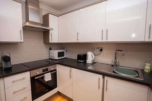 Kjøleskap, mikrobølgeovn, kaffetrakter/tekoker og høy barnestol