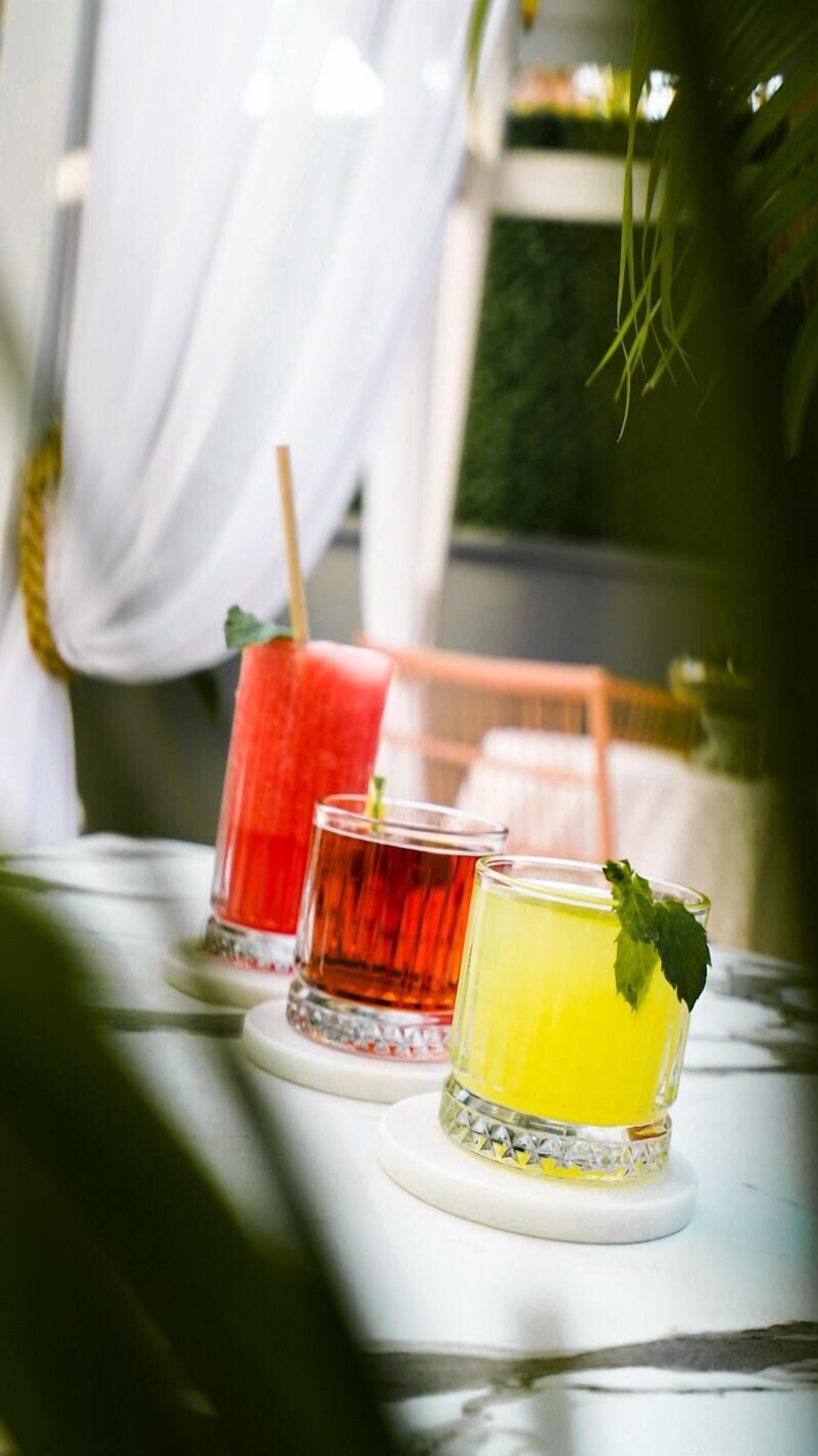 Three drinks on a table with a white cloth.