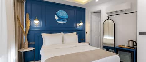 Un dormitorio moderno con una cama grande, mesitas de noche, un espejo y un equipo de aire acondicionado.