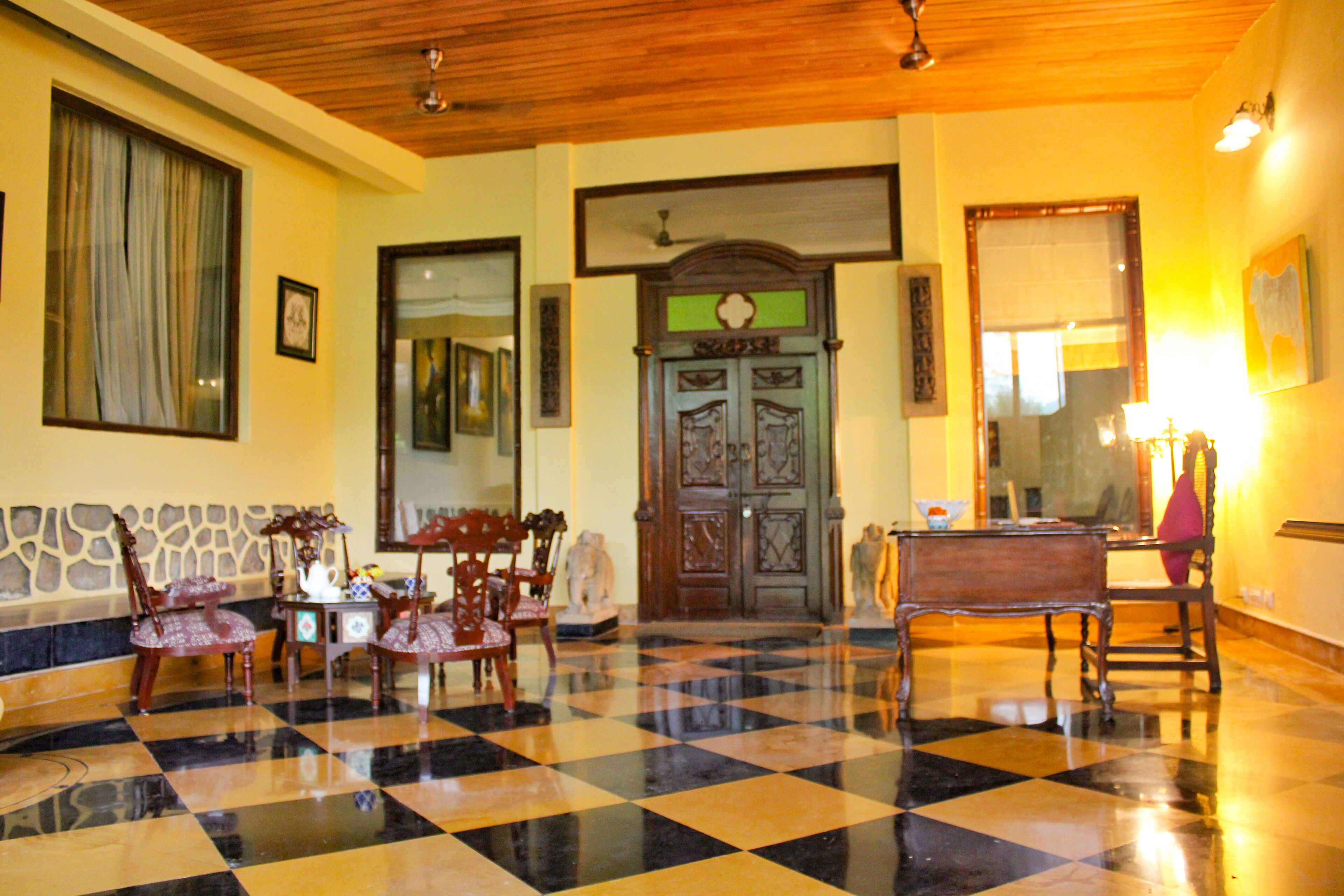 Un vestíbulo con piso a cuadros, muebles de madera y una puerta decorativa.