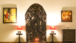 A lobby with a checkered floor, a central statue, two lamps, and framed artwork on the walls. - Tree of Life Resort, Dehradun Foothills (Dehradun)