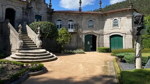 A historic building with a central courtyard, stone staircase, and green doors.