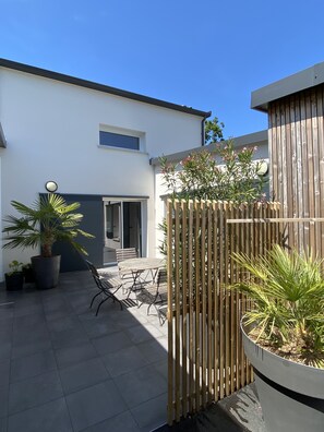 Relax in a serene outdoor space with a patio, potted plants, and comfortable seating.