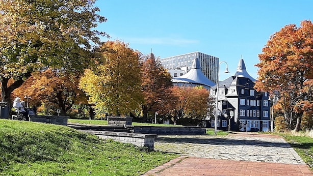A park with a cobblestone path leading to a historic building with a distinctive tower. - Ferienwohnung An den Kurwiesen (Masserberg)