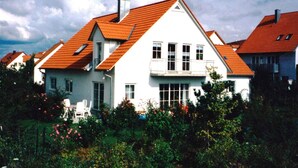 A white house with a red roof, multiple windows, and a balcony. - Ferienwohnung Buhl (Regensburg)