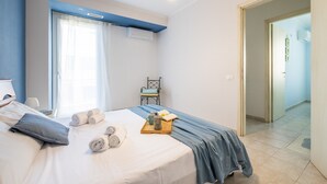 A bedroom with a bed, pillows, towels, a tray with a coffee pot, and a chair. - Holiday Home "Alloggio Nettuno" with Garden, Loggia and Wi-Fi (Villasimius)