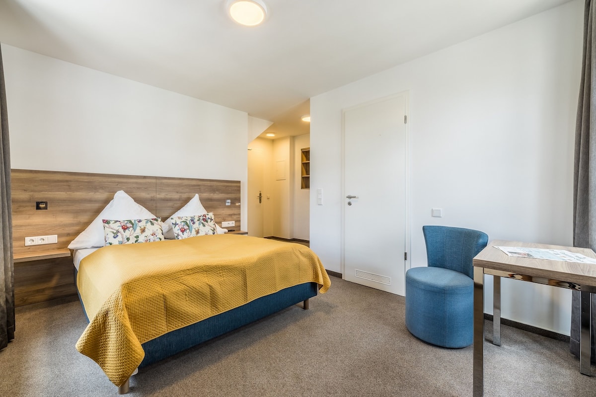 Una habitación de hotel con una cama, un escritorio y una silla.