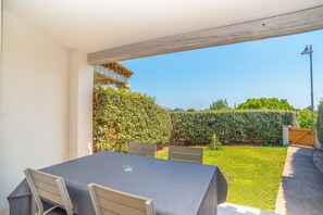A patio with a table and chairs, a wooden pergola, a hedge, and a gate. - Modern Holiday Home "Villa Rosa dei Venti" Near the Beach and with Sea View (OLBIA)
