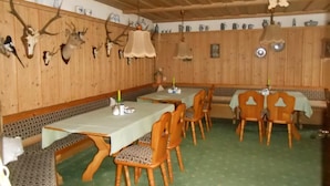 Un restaurante con paredes de madera, adornos de cuernos de ciervo y piso cubierto de alfombra verde.