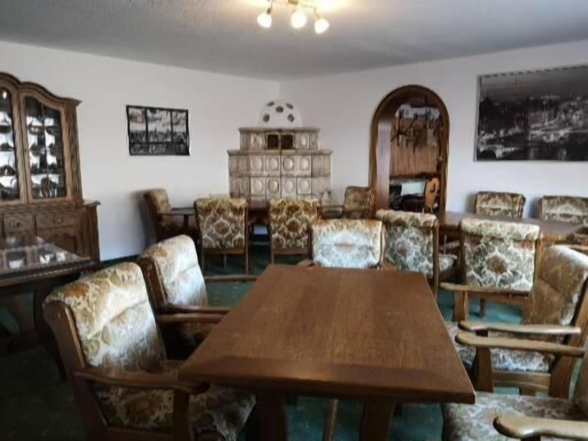 A dining room with a wooden table and patterned chairs, a cabinet, and wall art.