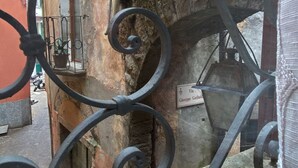 A narrow alleyway with a wrought iron gate, a potted plant, and a sign reading "Via Giuseppe Garibaldi". - Bridge Apartment Argegno (Argegno)