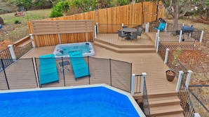 A backyard with a swimming pool, hot tub, and deck area with outdoor furniture. - Scenic Terrace | Private Pool, Hot Tub, Gameroom (Canyon Lake)