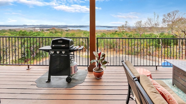 A balcony with a grill, a potted plant, a bench, and a view of the landscape. - Scenic Terrace | Private Pool, Hot Tub, Gameroom (Canyon Lake)