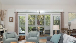 Un salon comprenant un canapé, des fauteuils, une table basse et un coin repas avec une table et des chaises.