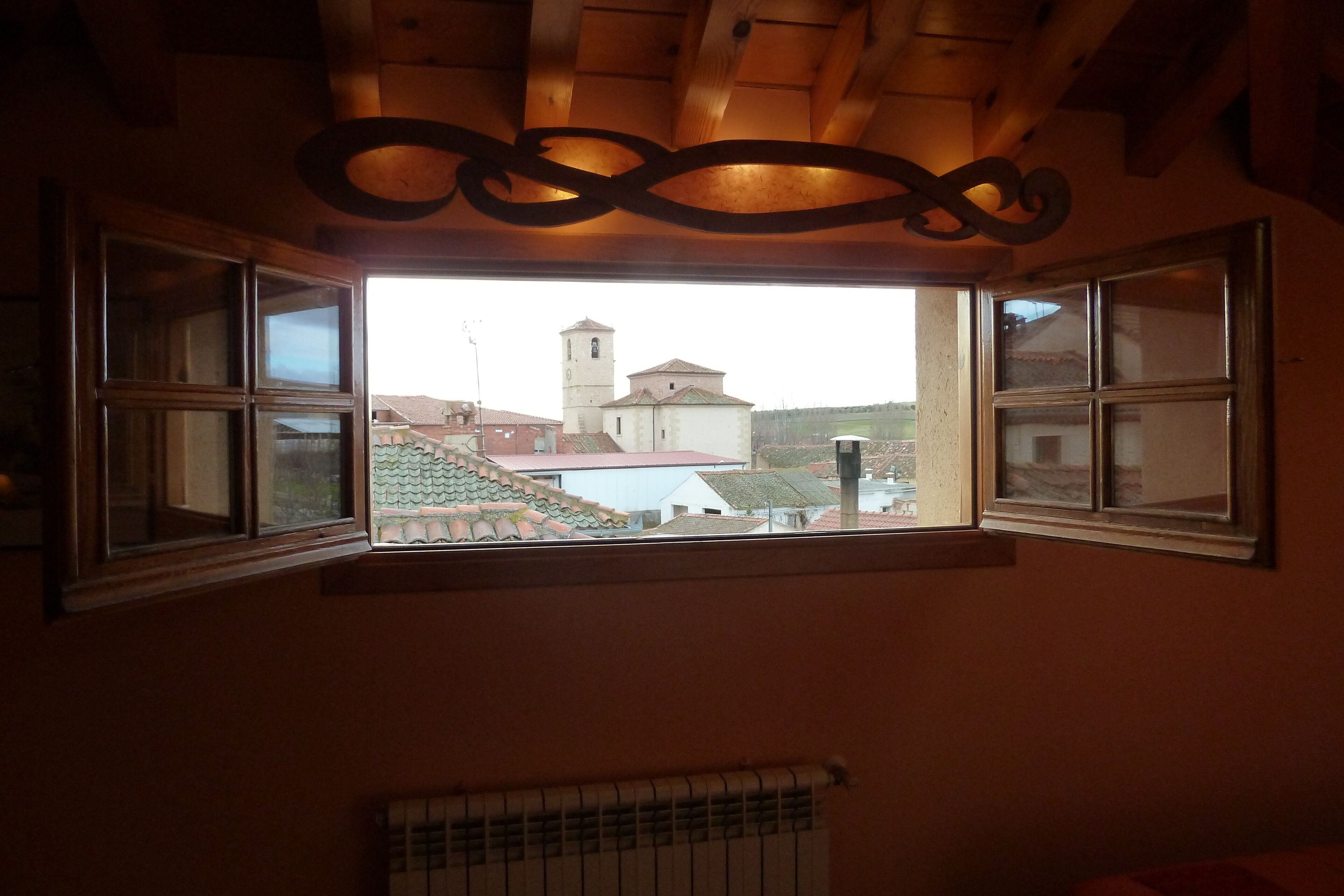 A room with a large window overlooking a building with a bell tower.