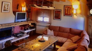 Ein gemütliches Wohnzimmer mit einer Couch, einem Couchtisch, einem Kamin und an den Wänden angebrachten Kunstwerken.