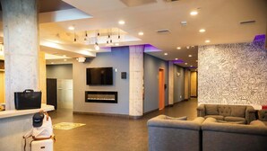 Un hall con mostrador de recepción, televisor de pantalla plana, chimenea y zona de estar.