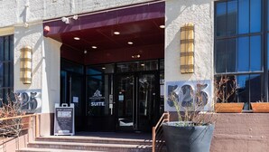 Entrada de un edificio con un letrero que dice 'EDWINS SUEIT' y un cartel de 'ALQUILERES DISPONIBLES'.