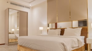 Ein Hotelzimmer mit einem großen Bett, einem Kleiderschrank, einem Nachttisch und einem Spiegel.