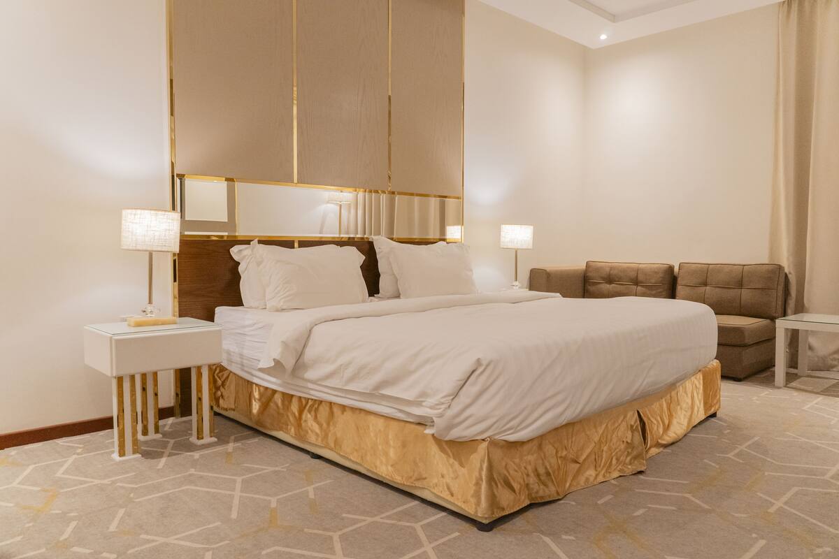Ett modernt hotellrum med en stor säng, en soffa och ett litet bord.