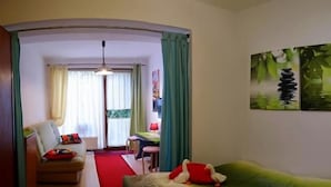 A living room with a sofa, a small table, and a chair. There are two paintings on the wall. - Willa Christo Dom z Dusza (Kolobrzeg)