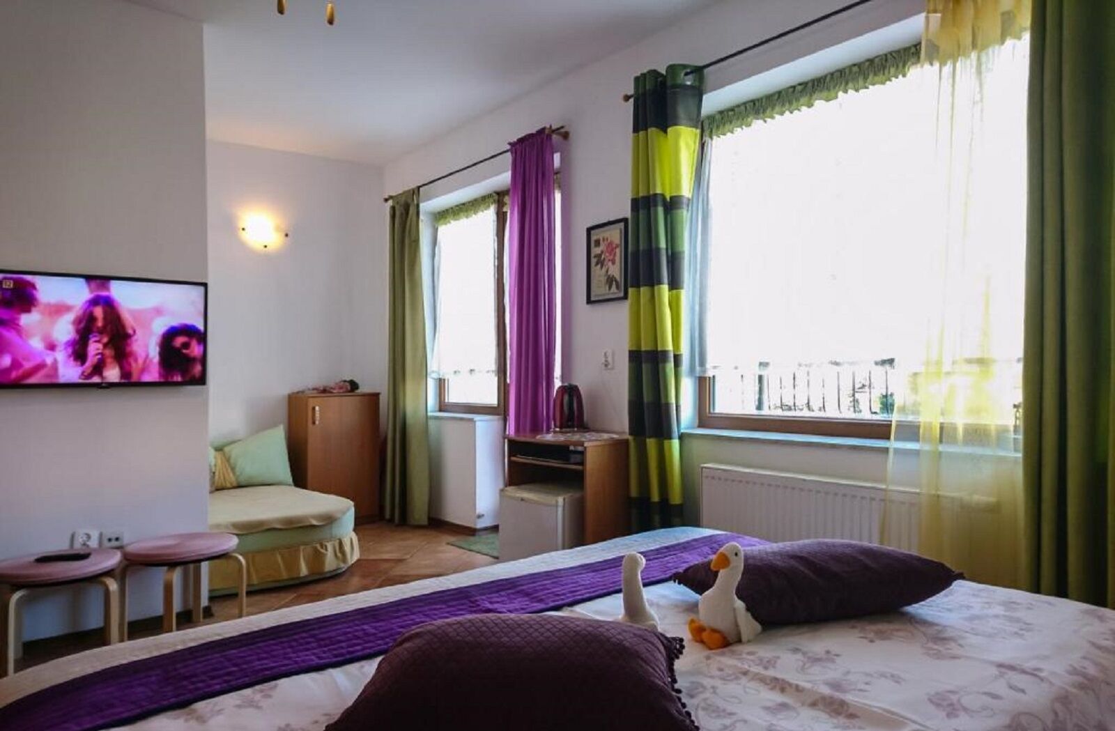 Una habitación de hotel con cama, escritorio, silla y televisor.