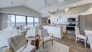 Una cocina moderna con armarios blancos, una isla grande y electrodomésticos de acero inoxidable.