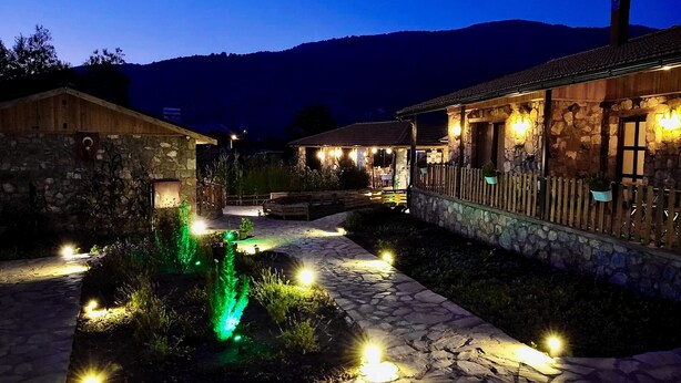 A stone building with a wooden exterior, a stone pathway, and a small water feature. - Dedehan Retreat Otel (Fethiye)