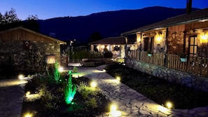 A stone building with a wooden exterior, a stone pathway, and a small water feature.