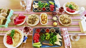 Et bord dækket med forskellige retter, herunder brød, salater og saucer, der antyder et måltid.