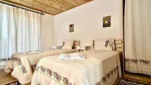 A double bed room with two nightstands, a wooden headboard, and a window with curtains.