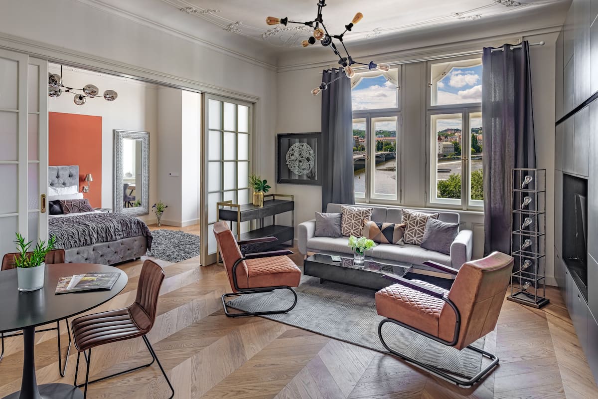 A modern living room with a sofa, chairs, a coffee table, and a fireplace.