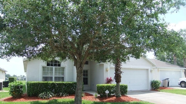 A residential house with a front yard, a driveway, and a garage. - Ref 03 Luxury 4 Bed Villa With Lake View own Pool (Kissimmee)