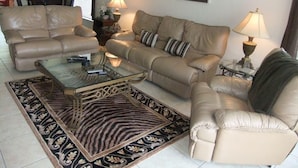 A living room with a beige sofa set, a glass coffee table, and a patterned rug. - Ref 03 Luxury 4 Bed Villa With Lake View own Pool (Kissimmee)