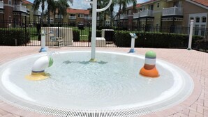 A water fountain with colorful sculptures in a courtyard surrounded by apartment buildings. - Ref 07 Modern 5 Bed Villa With own Pool Near Disney (Kissimmee)