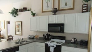 A kitchen with white cabinetry, a microwave, a stove, and a dishwasher. - Ref 07 Modern 5 Bed Villa With own Pool Near Disney (Kissimmee)