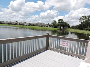 Enjoy leisurely activities on the deck overlooking the serene lake with a clear view of the surrounding residential area.