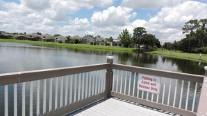 Un lago con una plataforma de madera y un cartel que indica 'Solo pesca y liberación'.