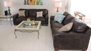 A living room with two leather sofas, a glass coffee table, and two lamps. - Ref 01 Stunning 4 Bed Villa With own Pool Spa Lake View (Kissimmee)