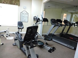 Ein Fitnessstudio mit Ergometer, Laufbändern und einer Spiegelwand.