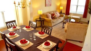 A dining area with a table set for four, a sofa, and a chair in the background. - Ref 37 Beautiful 6 Bed Villa With Pool Gated Resort (Davenport)