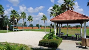 A covered pavilion with a tiled roof, a volleyball net, and palm trees in the background. - Ref 37 Beautiful 6 Bed Villa With Pool Gated Resort (Davenport)