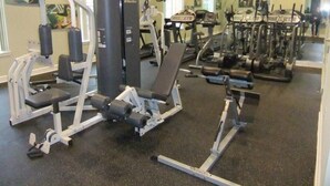 A gym with various exercise equipment including treadmills, weight machines, and a bench press. - Ref 01bv Stunning 5 Bed 4 Bath Villa With own Pool (Kissimmee)