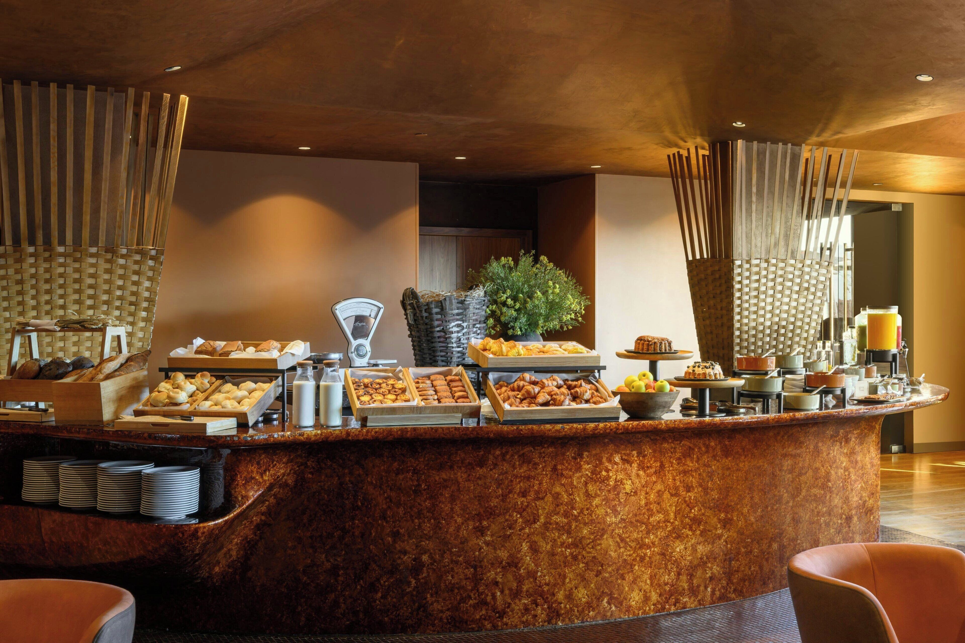 A breakfast buffet with various pastries, fruits, and beverages.