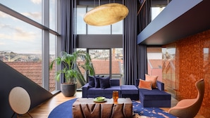 Una sala de estar moderna con un ventanal grande, un conjunto de sofá, una mesita de centro y una planta en maceta.