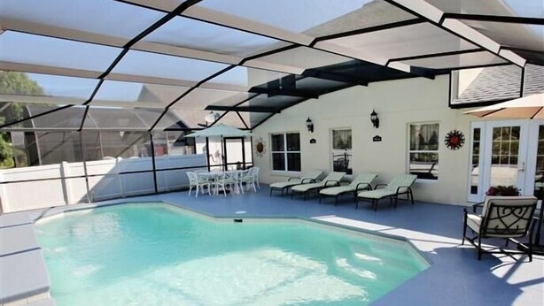 Una piscina techada con sillas de descanso y un patio.